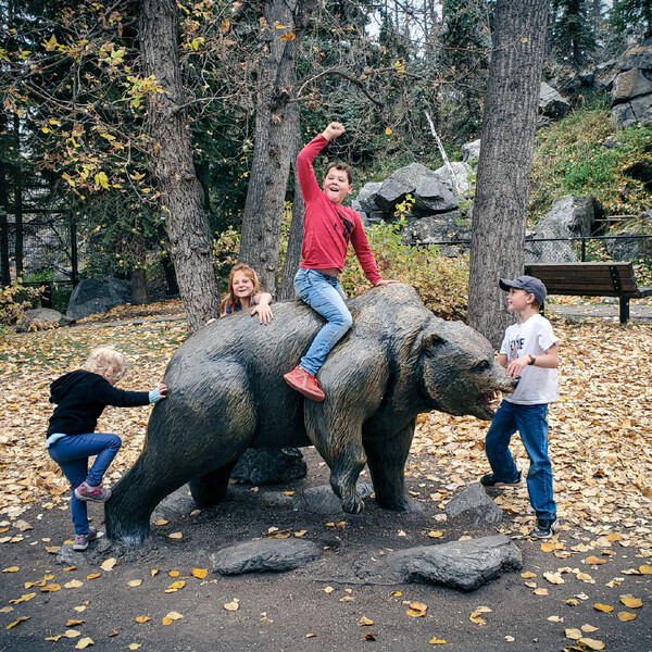 four students play with a bear statue with NorthStar Academy Online School